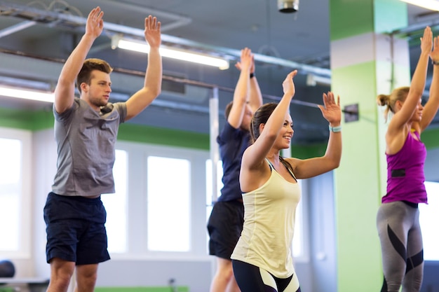 concetto di fitness, sport e stile di vita sano - gruppo di persone felici che si esercitano in palestra