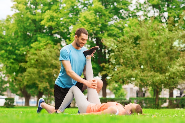 concetto di fitness, sport, formazione e stile di vita - coppia sorridente che si estende all'aperto