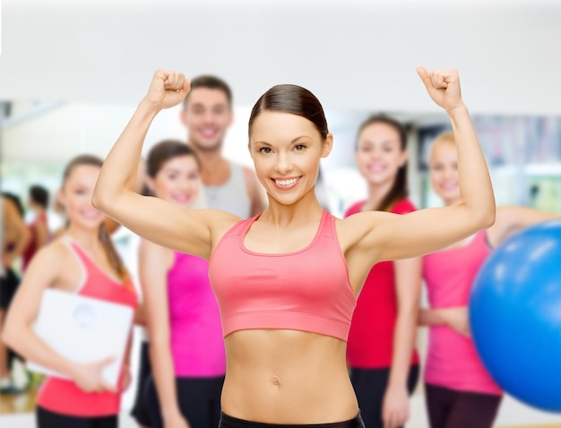 concetto di fitness, sport, formazione e stile di vita - personal trainer con un gruppo di persone sorridenti in palestra