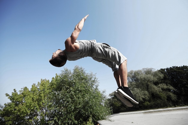 concetto di fitness, sport, parkour e persone - giovane che salta nel parco estivo