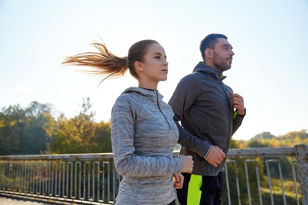 concetto di fitness, sport, persone e jogging - coppia felice che corre all'aperto