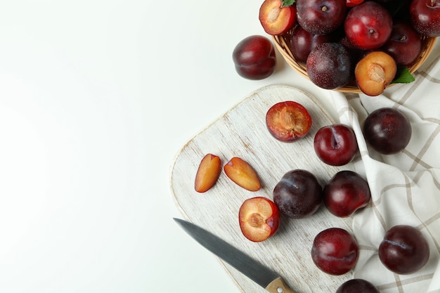 Concetto di frutta con prugne su sfondo bianco.