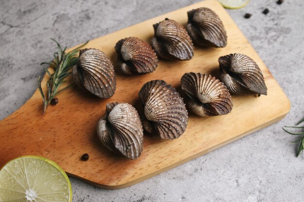 Concetto di frutti di mare freschi di colombe su tavola da taglio in legno con limone