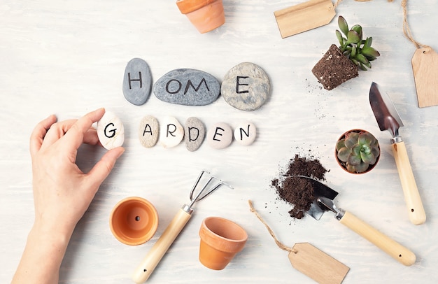 Concetto di giardinaggio domestico. Lay piatto con il testo il mio giardino su pietre e attrezzi da giardinaggio. Composizione minima vista dall'alto