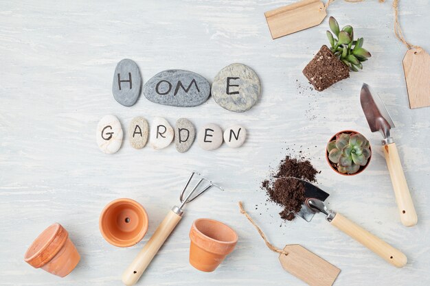 Concetto di giardinaggio domestico. Lay piatto con il testo il mio giardino su pietre e attrezzi da giardinaggio. Composizione minima vista dall'alto