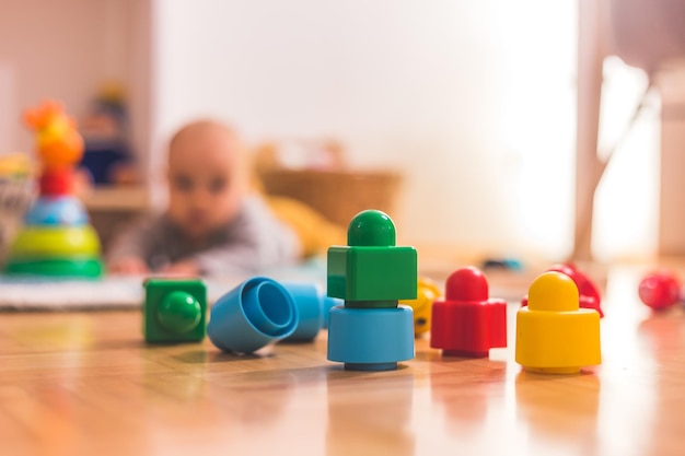 Concetto di gioco del bambino bambino Blocchi giocattolo colorati in primo piano che giocano bambino sullo sfondo sfocato