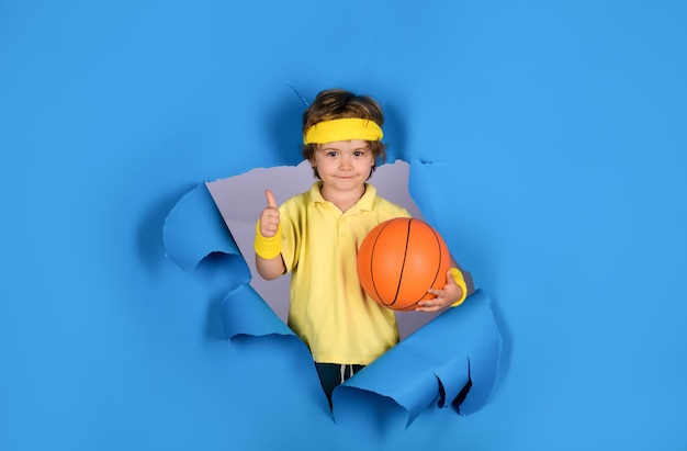 Concetto di gioco di allenamento di pallacanestro ragazzo carino che gioca a basket si diverte con il gioco sportivo bambino felice tiene la palla