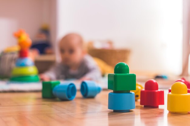 Concetto di gioco per bambini piccoli Blocchi giocattolo colorati in primo piano che giocano bambino sullo sfondo sfocato