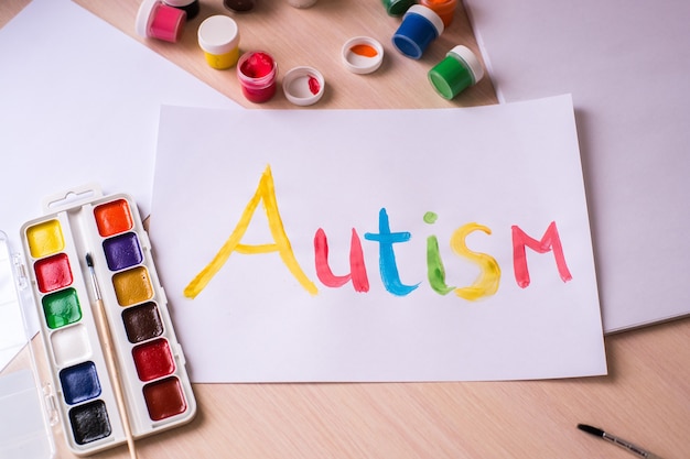 Concetto di giornata mondiale di consapevolezza dell'autismo. cuore e mani di carta su sfondo blu. Disturbo dello spettro autistico (ASD).