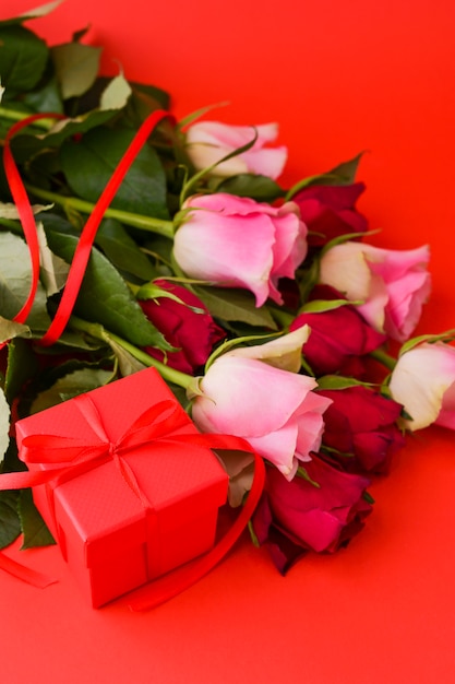 Concetto di giorno delle donne e cartolina d'auguri di San Valentino. Composizione con regalo, rose e busta. Spazio per il testo.