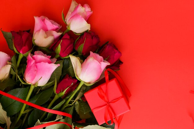 Concetto di giorno delle donne e cartolina d'auguri di San Valentino. Composizione con regalo, rose. Spazio per il testo.