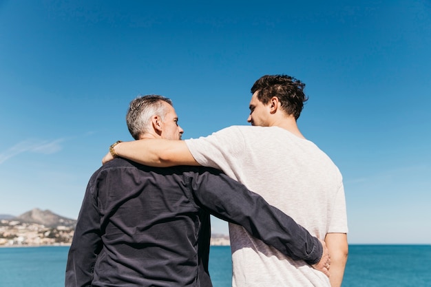 Concetto di giorno di padri con padre e figlio di fronte al mare