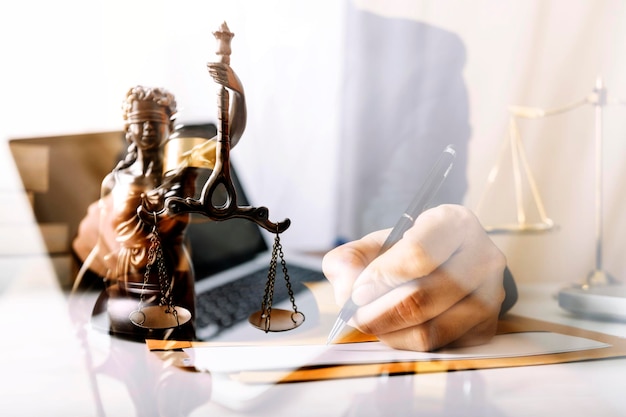 Concetto di giustizia e diritto Giudice maschile in un'aula di tribunale con il martelletto che lavora con il computer e gli occhiali della tastiera di aggancio sul tavolo alla luce del mattino
