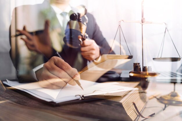 Concetto di giustizia e diritto Giudice maschile in un'aula di tribunale con il martelletto che lavora con il computer e gli occhiali della tastiera di aggancio sul tavolo alla luce del mattino