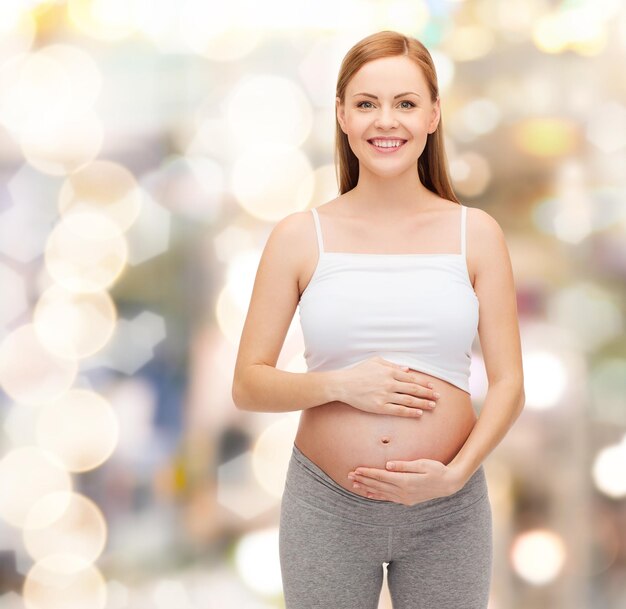 concetto di gravidanza, maternità e felicità - felice futura madre che tocca la sua pancia