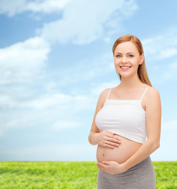 concetto di gravidanza, maternità e felicità - felice futura madre che tocca la sua pancia