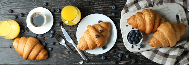 Concetto di gustosa colazione con croissant su legno