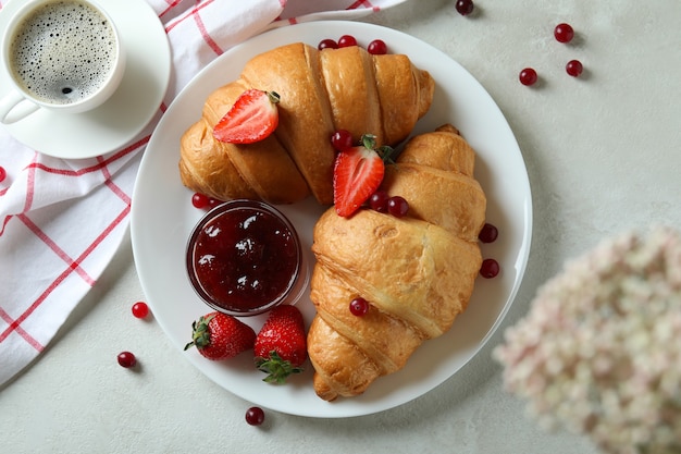 Concetto di gustosa colazione con croissant sulla tabella testurizzata bianca