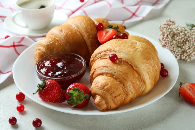 Concetto di gustosa colazione con croissant sulla tabella testurizzata bianca