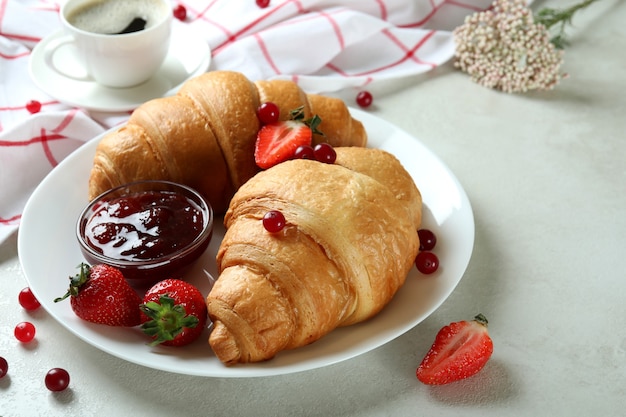 Concetto di gustosa colazione con croissant sulla tabella testurizzata bianca