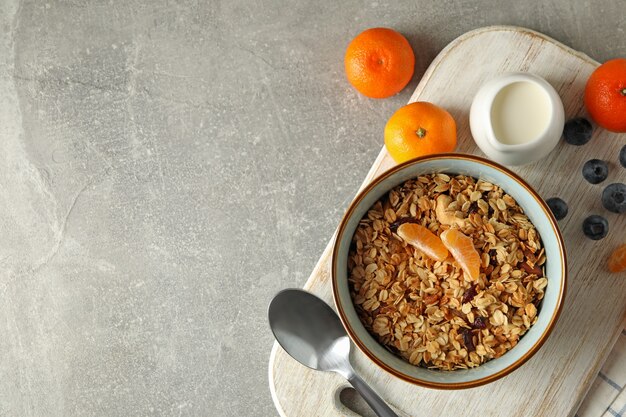 Concetto di gustosa colazione con muesli su sfondo grigio