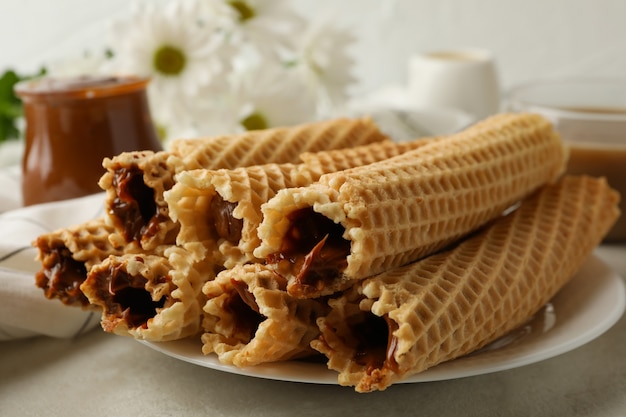 Concetto di gustosa colazione con rotoli di wafer con latte condensato