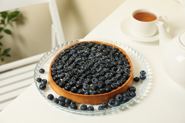 Concetto di gustosa colazione con torta di mirtilli sul tavolo bianco