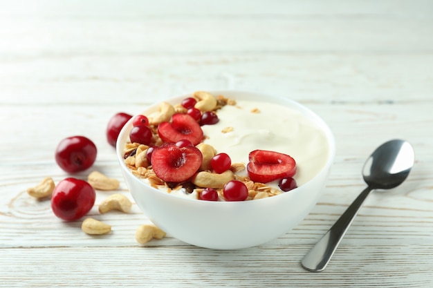 Concetto di gustosa colazione con yogurt sul tavolo di legno