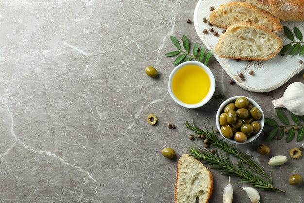 Concetto di gustoso mangiare con olio d'oliva sul tavolo grigio testurizzato