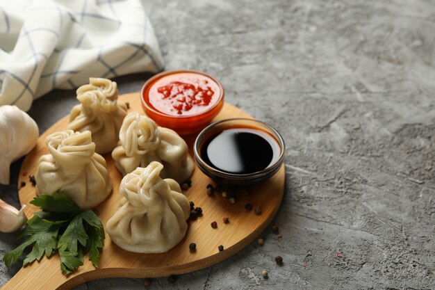 Concetto di gustoso pranzo con bordo di khinkali su sfondo grigio