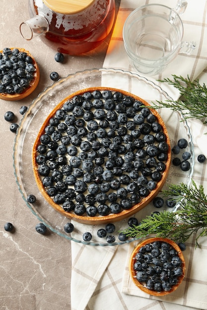 Concetto di gustoso pranzo con torta di mirtilli sul tavolo grigio