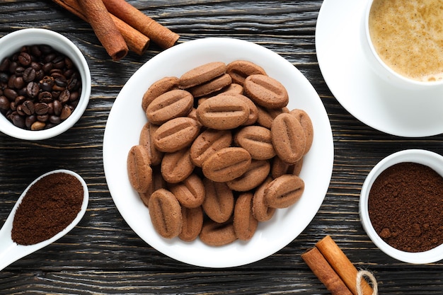 Concetto di gustoso spuntino per biscotti a bevanda calda a forma di semi di caffè