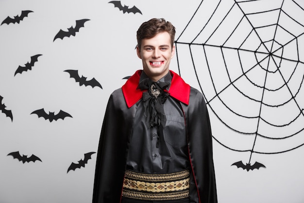 Concetto di Halloween del vampiro - Ritratto del vampiro caucasico bello in costume di Halloween nero e rosso.