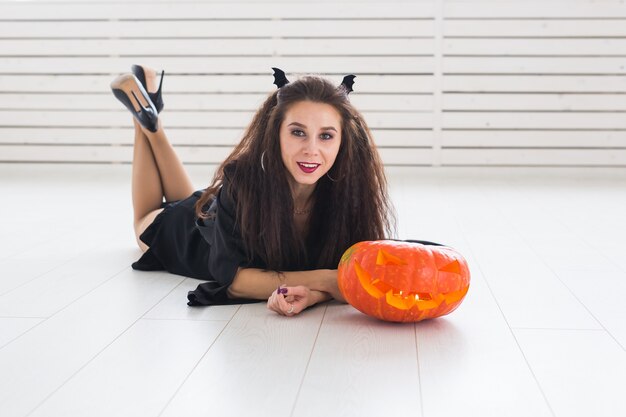 Concetto di Halloween - strega felice con zucca Jack-o'-lantern.