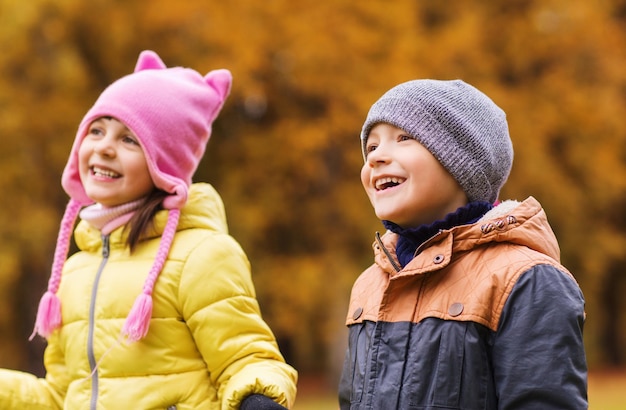 concetto di infanzia, tempo libero, amicizia e persone - gruppo di bambini felici nel parco autunnale