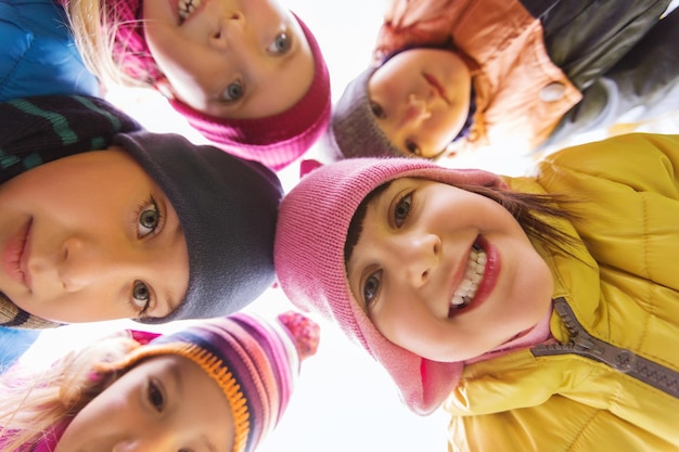 concetto di infanzia, tempo libero, amicizia e persone - un gruppo di bambini felici si affaccia in cerchio