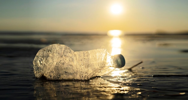 Concetto di inquinamento sfondo creativo Una bottiglia di plastica che galleggia nell'oceano