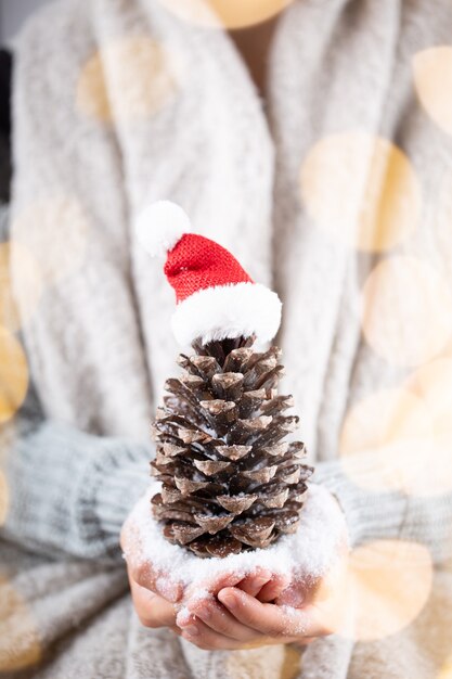 Concetto di inverno Giovani mani che tengono decorazioni natalizie. Idea di decorazione natalizia. Decorazioni natalizie nelle mani di una donna, sfondo con bokeh oro.