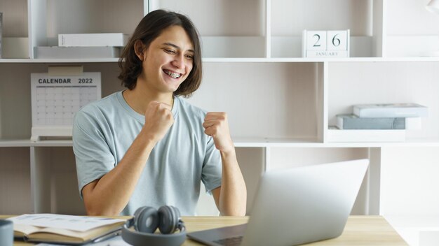 Concetto di istruzione a distanza Ragazzo adolescente fa gesti e parla con l'insegnante in classe online