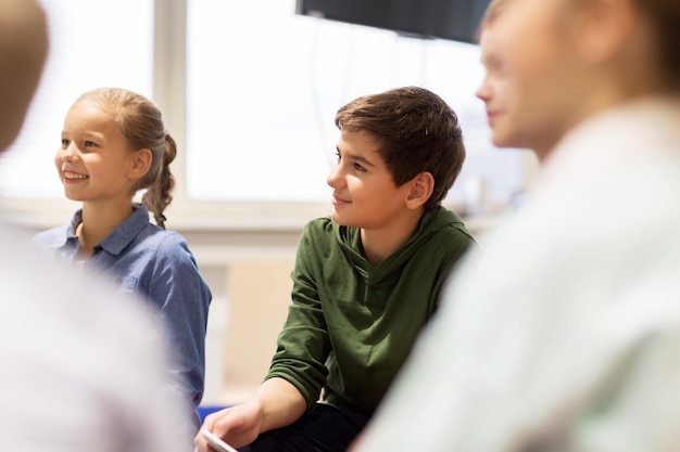 concetto di istruzione, bambini e persone - gruppo di bambini felici o amici che imparano a scuola