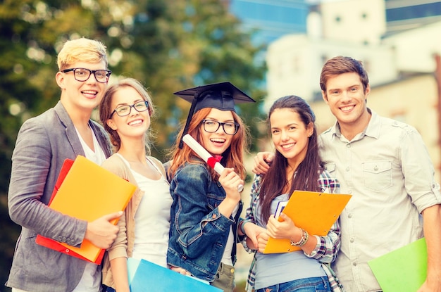 concetto di istruzione, campus e adolescenti - gruppo di studenti o adolescenti con file, cartelle, occhiali e diploma