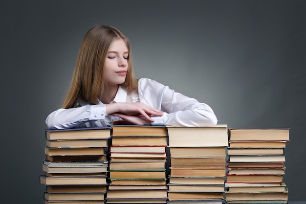 Concetto di istruzione e scuola sorridente piccola studentessa con molti libri