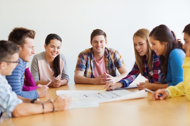 concetto di istruzione, scuola, architettura e persone - gruppo di studenti sorridenti con riunione del progetto al chiuso