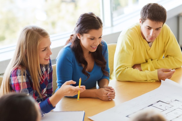 concetto di istruzione, scuola, architettura e persone - gruppo di studenti sorridenti con riunione del progetto al chiuso