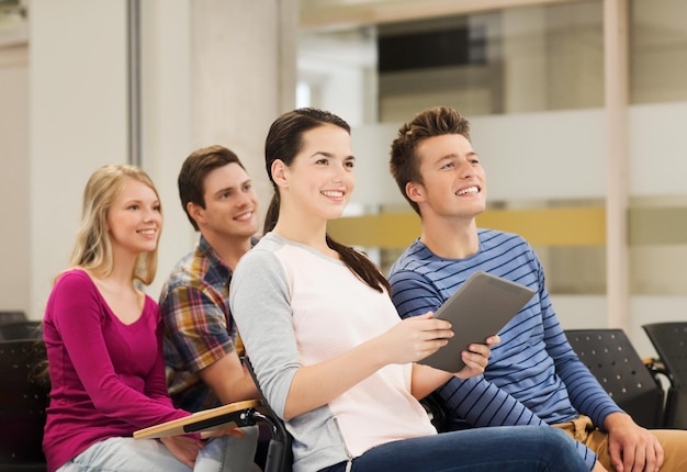 concetto di istruzione, scuola superiore, lavoro di squadra e persone - gruppo di studenti sorridenti con computer tablet pc seduti in aula