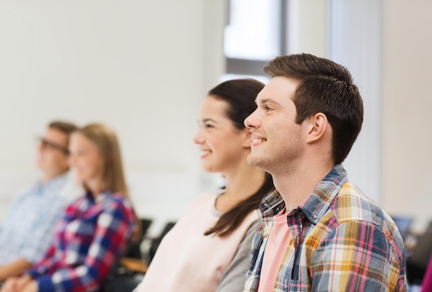 concetto di istruzione, scuola superiore, lavoro di squadra e persone - gruppo di studenti sorridenti seduti in aula