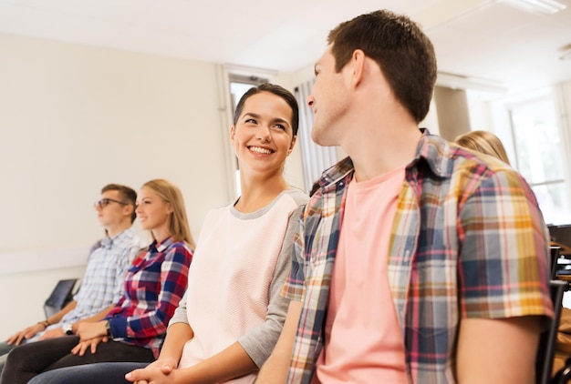 concetto di istruzione, scuola superiore, lavoro di squadra e persone - gruppo di studenti sorridenti seduti in aula