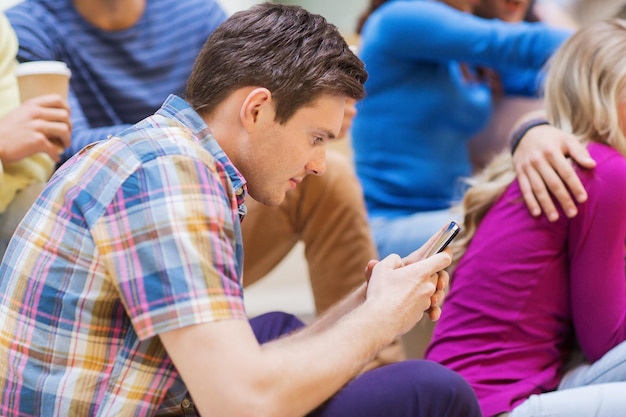 concetto di istruzione, scuola superiore, tecnologia e persone - gruppo di studenti sorridenti con smartphone in aula