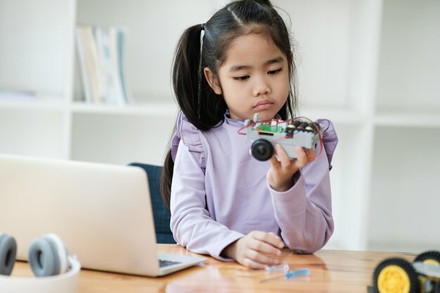 Concetto di istruzione STEM Ragazza asiatica che impara a progettare robot