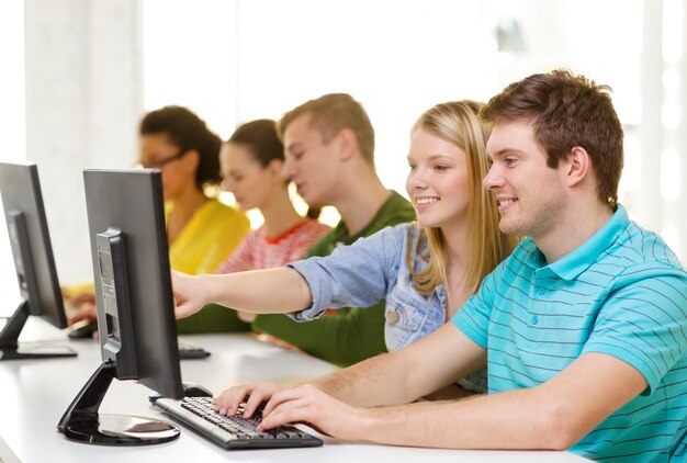 concetto di istruzione, tecnologia e scuola - studenti sorridenti in classe di computer a scuola